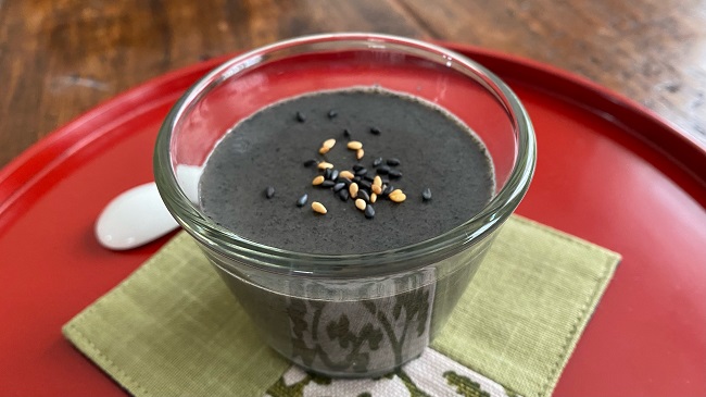 Schwarzer Sesam-Pudding in einem Glas serviert mit Sesamsamen als Topping