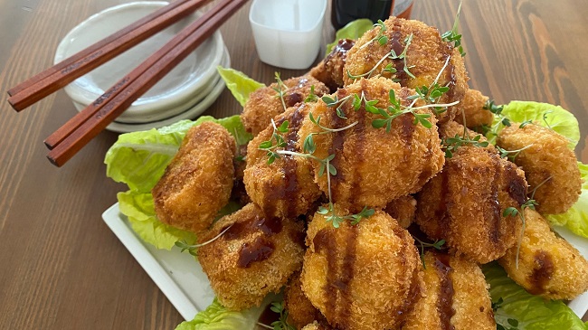 Kürbiskroketten mit Salat und Stäbchen serviert