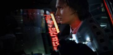 Jake Adelstein im Auto, Neonlichter im Hintergrund