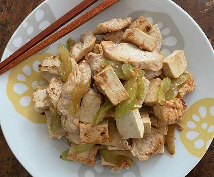 Hähnchen mit Sellerie und Tofu auf Teller mit Stäbchen serviert