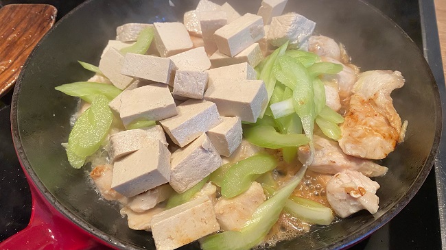 Hähnchen wird mit Tofu und Sellerie in der Pfanne gebraten