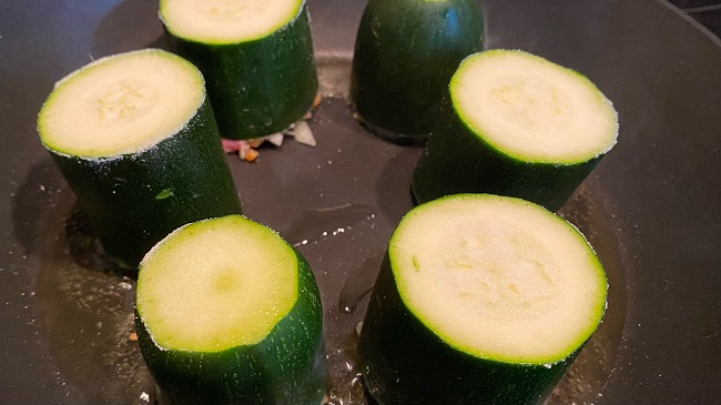 Gefüllte Zucchini werden mit der Hackfleisch-Seite nach unten gebraten