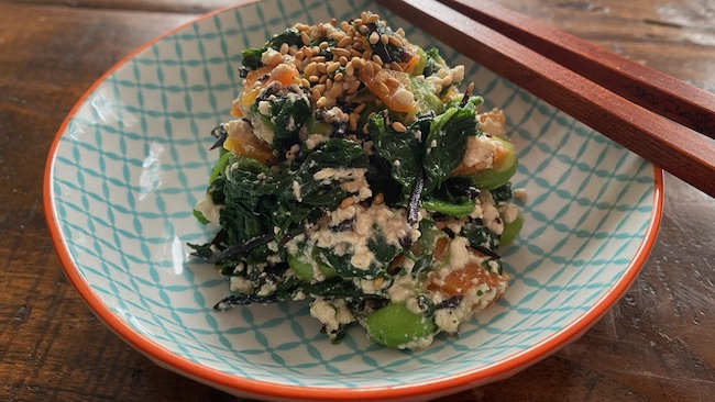 Tōfu mit Spinat, Karotte und Hijiki im Schälchen mit Stäbchen serviert