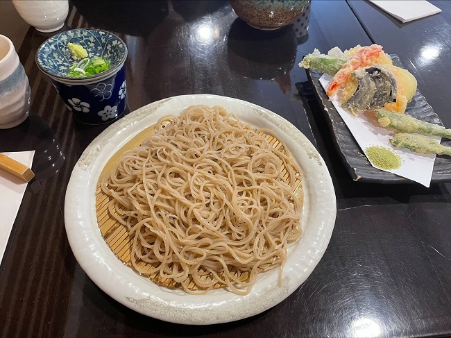 Sobanudeln auf Bambusunterlage mit Tempura, Frühlingszwiebeln und Wasabi als Beilage