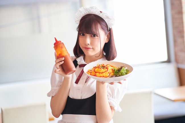 Maid hält im Maid Café Honey Honey einen Teller Reis mit Omelett hoch