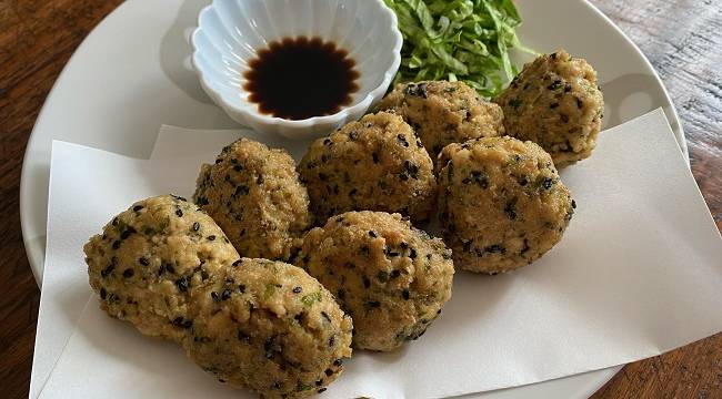 Frittierte Tofu-Bällchen, serviert mit Sojasauce und grünem Salat