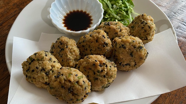 Frittierte Tofu-Bällchen, serviert mit Sojasauce und grünem Salat