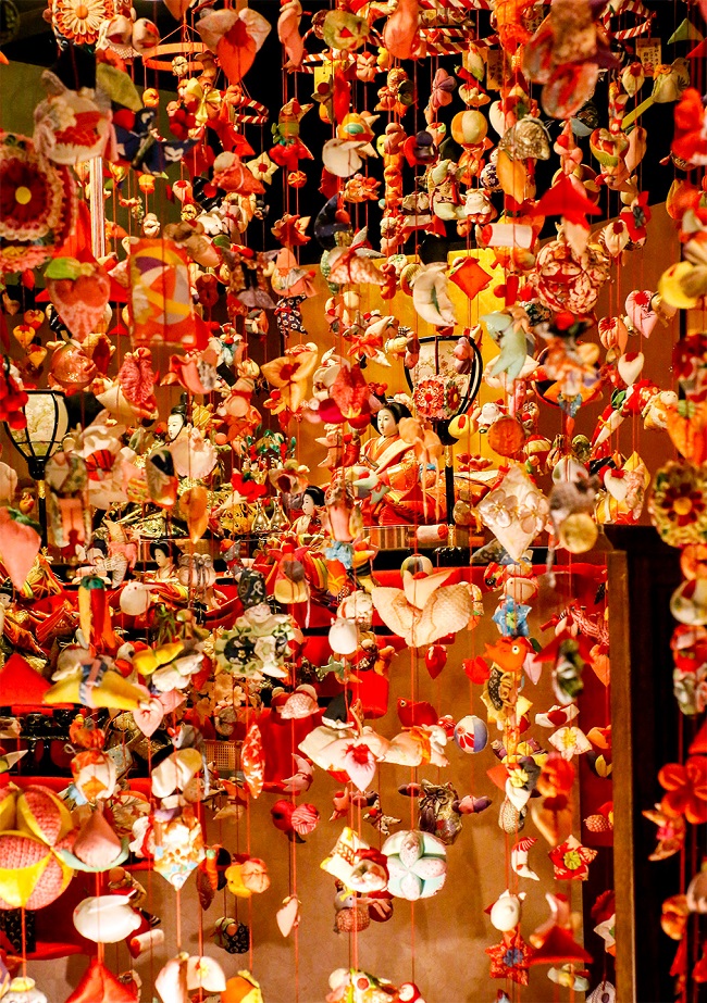 An roten Bändern befestigte Stoff-Figuren beim japanischen Puppenfest in Inatori