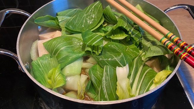 Tofu und Pak Choy im Topf (Blätter liegen obenauf)