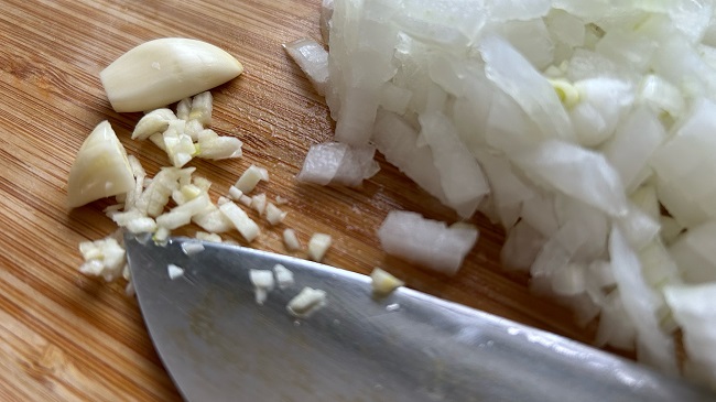 Knoblauch und Zwiebel wird geschnitten