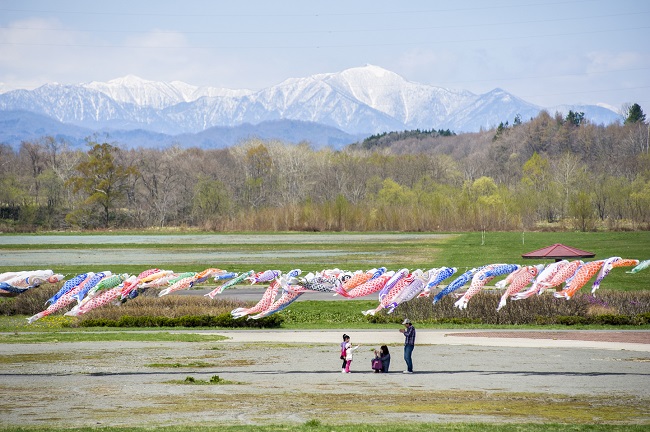 Familie mit Kindern unter den Koi-Flaggen am Rekifune-Fluss