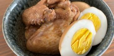Gekochte Hähnchenflügel mit einem halbierten gekochten Ei in einer Schale serviert