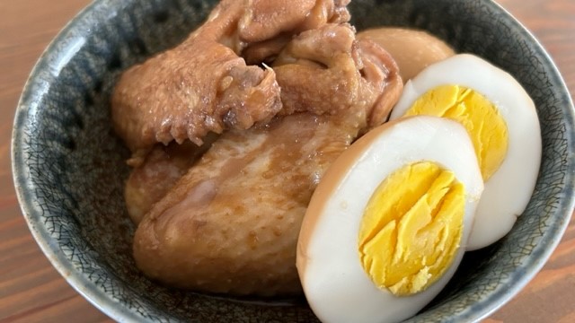 Gekochte Hähnchenflügel mit einem halbierten gekochten Ei in einer Schale serviert