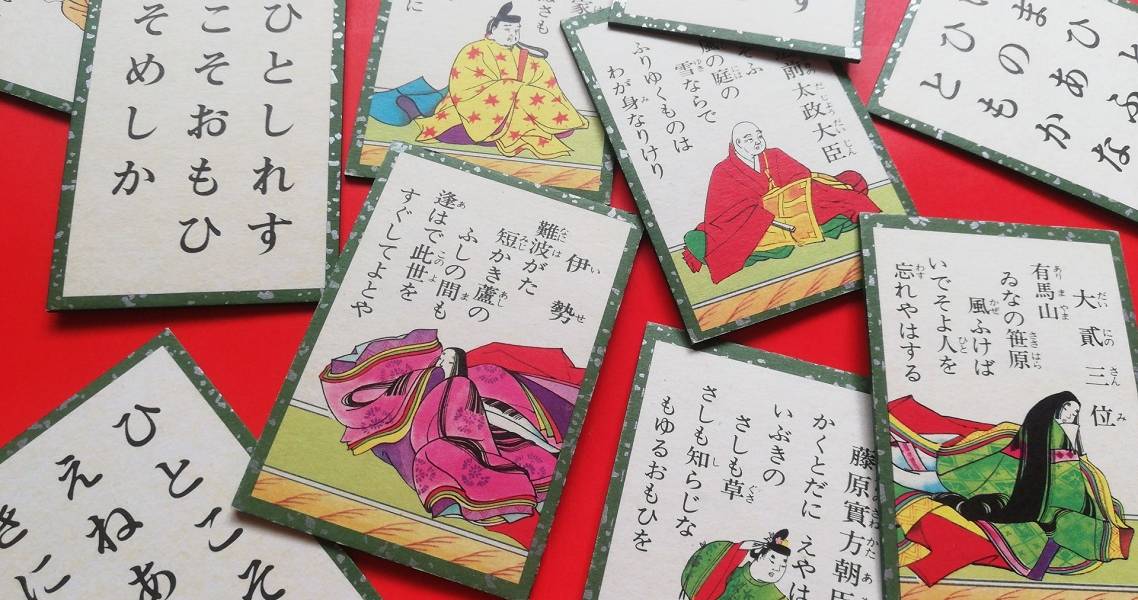 Spielkarten des Kartenspiels "Hyakunin isshu" auf roter Oberfläche