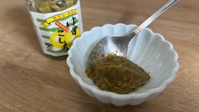 Yuzu-Kosho-Paste im Glas und abgefüllt mit Löffel im Schälchen