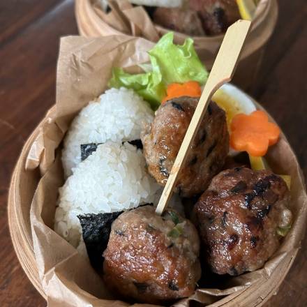 Japanische Hackbällchen serviert mit Reisbällchen und Salat