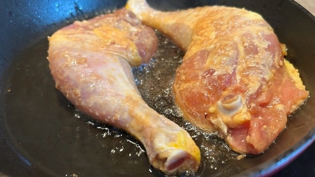 Hähnchenschenkel werden in der Pfanne gebraten