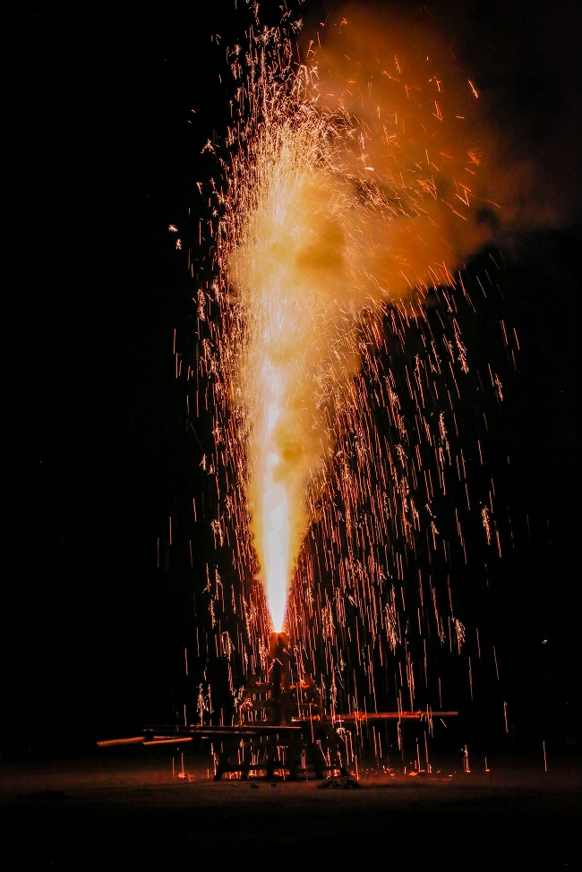 Goldregen prasselt auf den tragbaren Schrein, als das Handrohrfeuerwerk explodiert