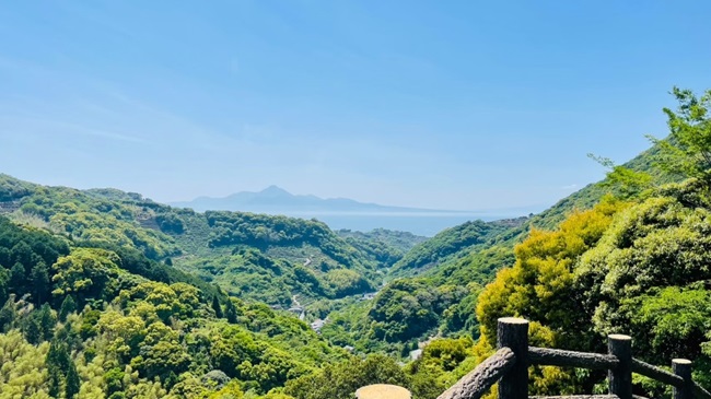 Blick von der Aussichtsplattform der Reigandō-Höhle über die grünen Hügel der Berge und das angrenzende Meer
