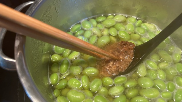 Miso-Paste wird zu den Edamame-Bohnen ins Kochwasser gegeben