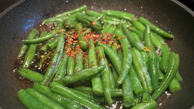 Grüne Bohnen in der Pfanne mit Paprika-Flocken
