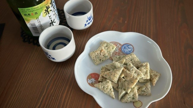 Ebi-senbei (Garnelen-Cracker) auf Teller serviert mit Sake