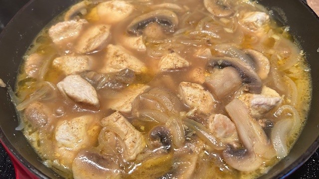 Curry-Sauce mit Fleisch, Gemüse und Pilzen wird in der Pfanne zubereitet