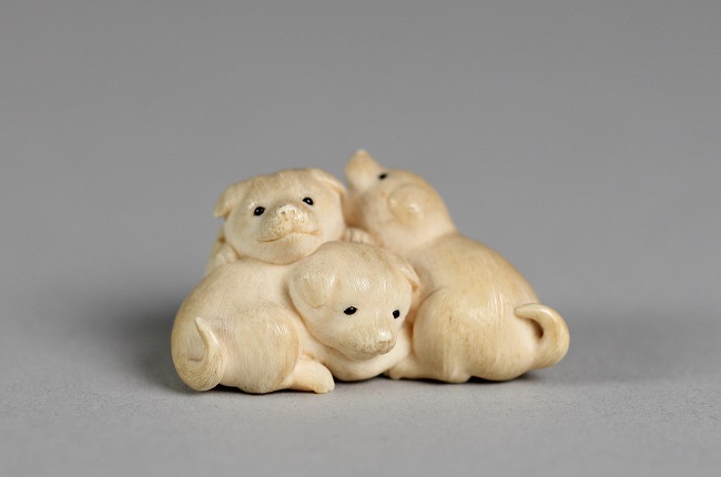 Netsuke aus Elfenbein aus dem 18. Jh. Es zeigt drei Welpen.