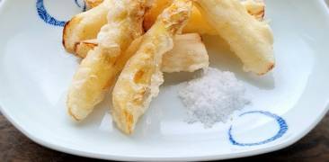 Spargel-Tempura mit einem Häufchen Salz auf weißen Teller mit blauem Muster serviert