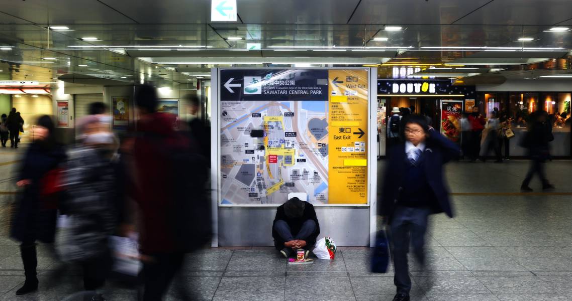 Unbekannter Obdachloser sitzt im Bahnhof Osaka in Osaka, Japan.