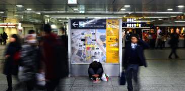Unbekannter Obdachloser sitzt im Bahnhof Osaka in Osaka, Japan.